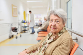 Seniorin im Wartebereich eines Krankenhauses