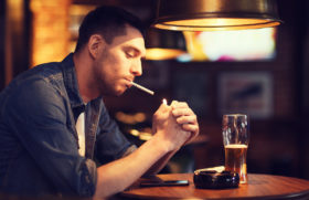 Mann trinkt Bier und raucht