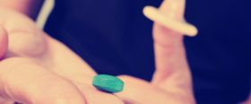 Pille und Kondom auf der Hand